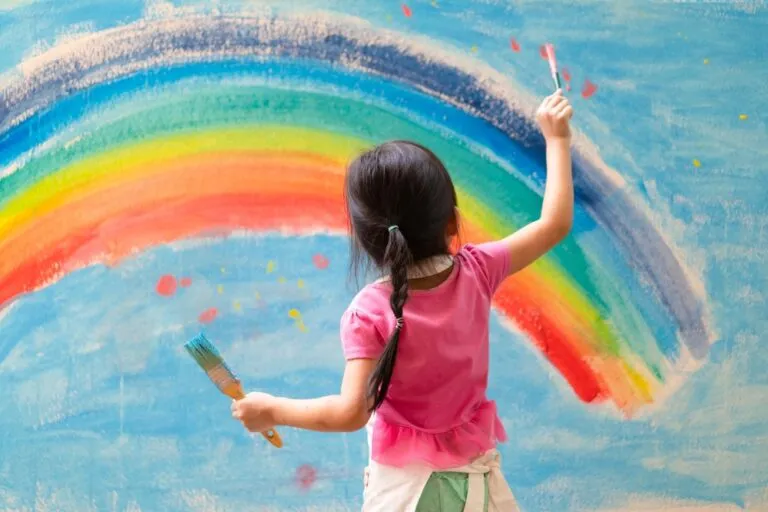 Unidentified,Little,Girl,Is,Painting,The,Colorful,Rainbow,And,Sky