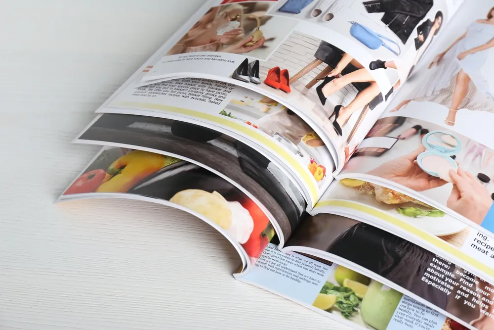 Many,Open,Magazines,On,White,Wooden,Table,,Above,View